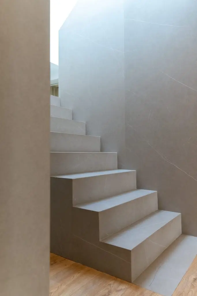 Escalera central de gres porcelánico en vivienda unifamiliar rehabilitada en Córdoba