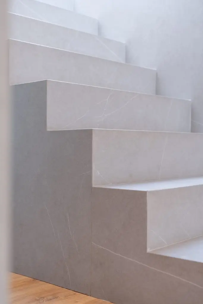 Escalera central de gres porcelánico en vivienda unifamiliar rehabilitada en Córdoba
