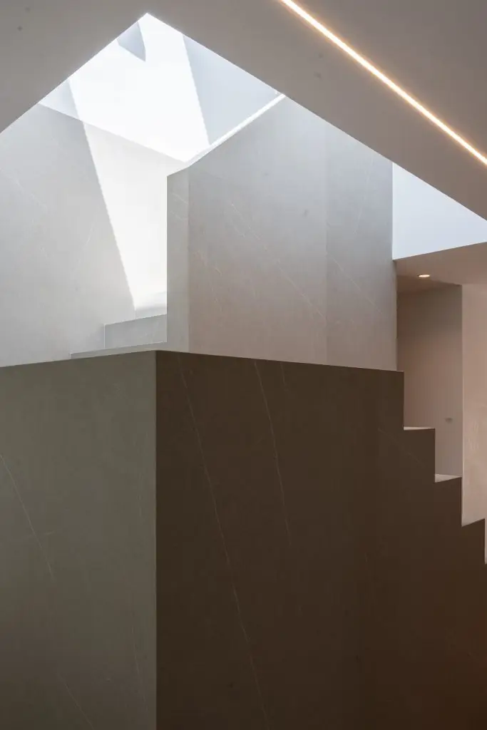 Escalera central de gres porcelánico en vivienda unifamiliar rehabilitada en Córdoba