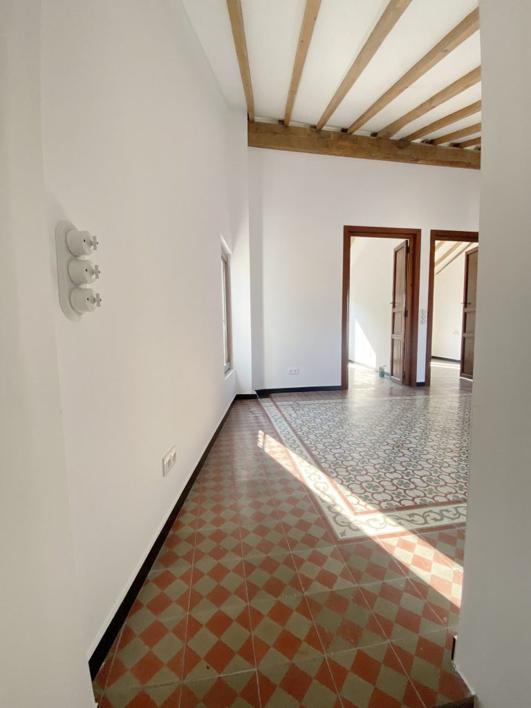 Escalera con vigas de madera vistas en casa de pueblo Alfara